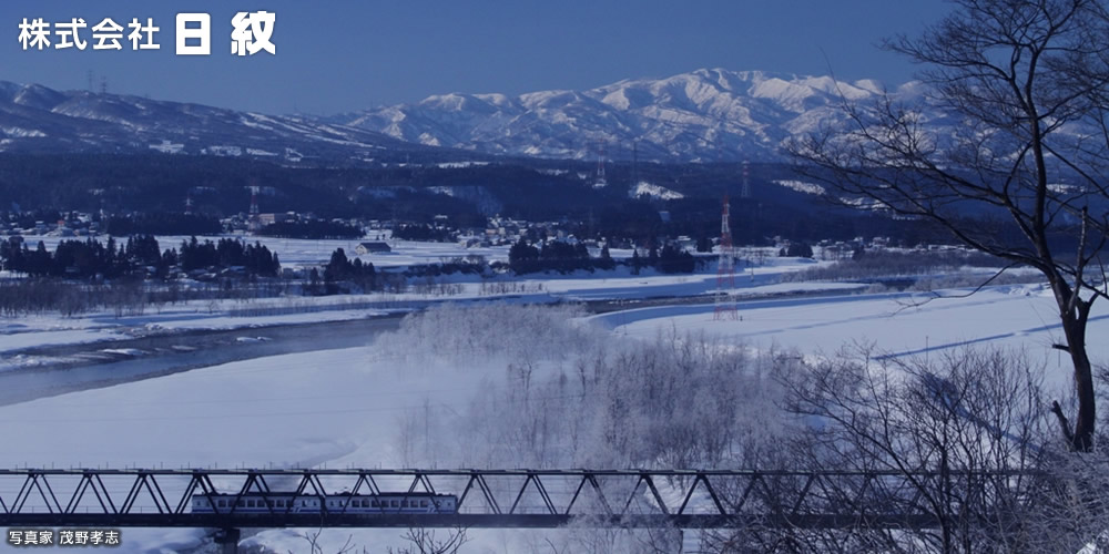 日紋のある新潟県十日町市の冬の風景：信濃川を渡るほくほく線